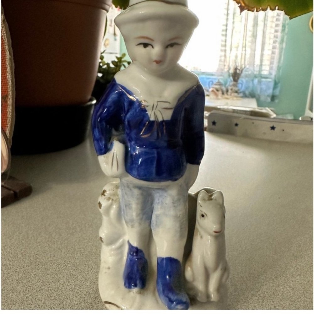 Holland Delft Blue style, a boy walking with his dog and carrying a package or b